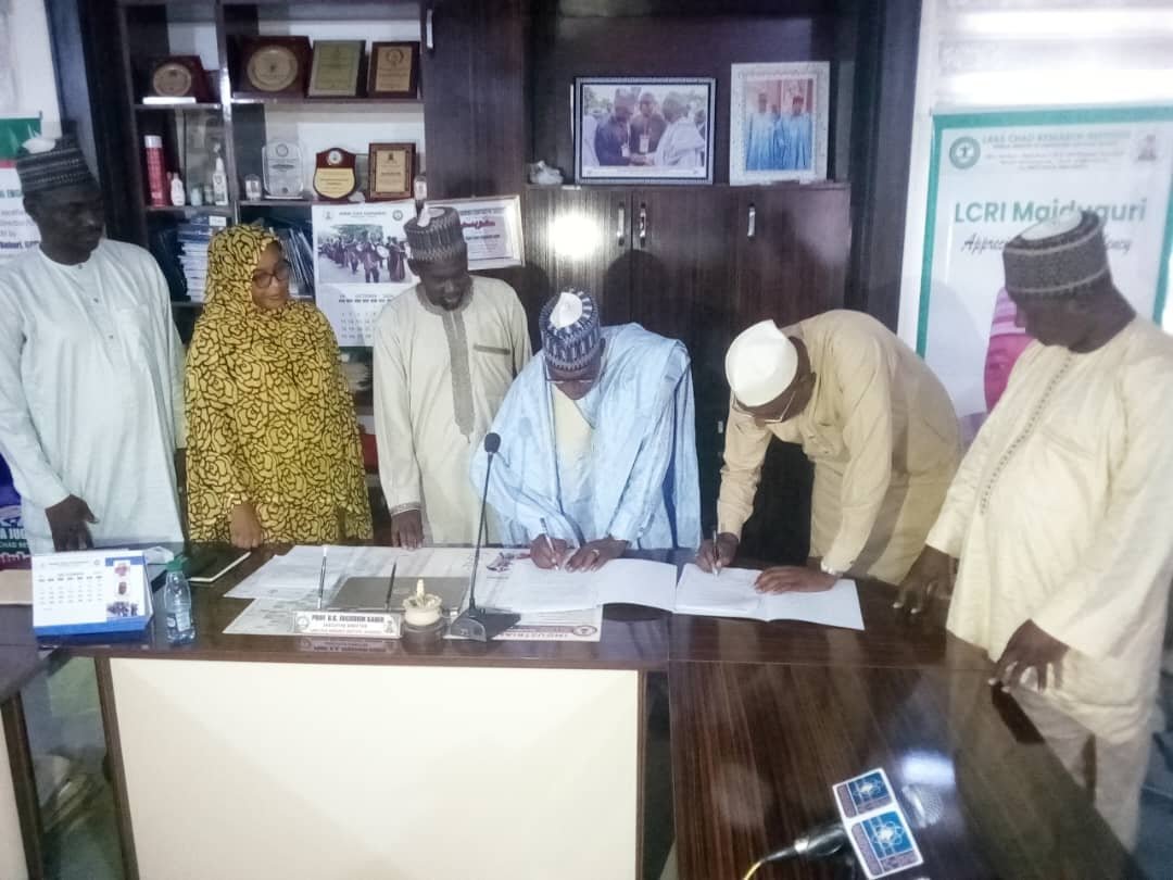 Participants signing documents during an institutional engagement at Lake Chad Research Institute, Maiduguri.